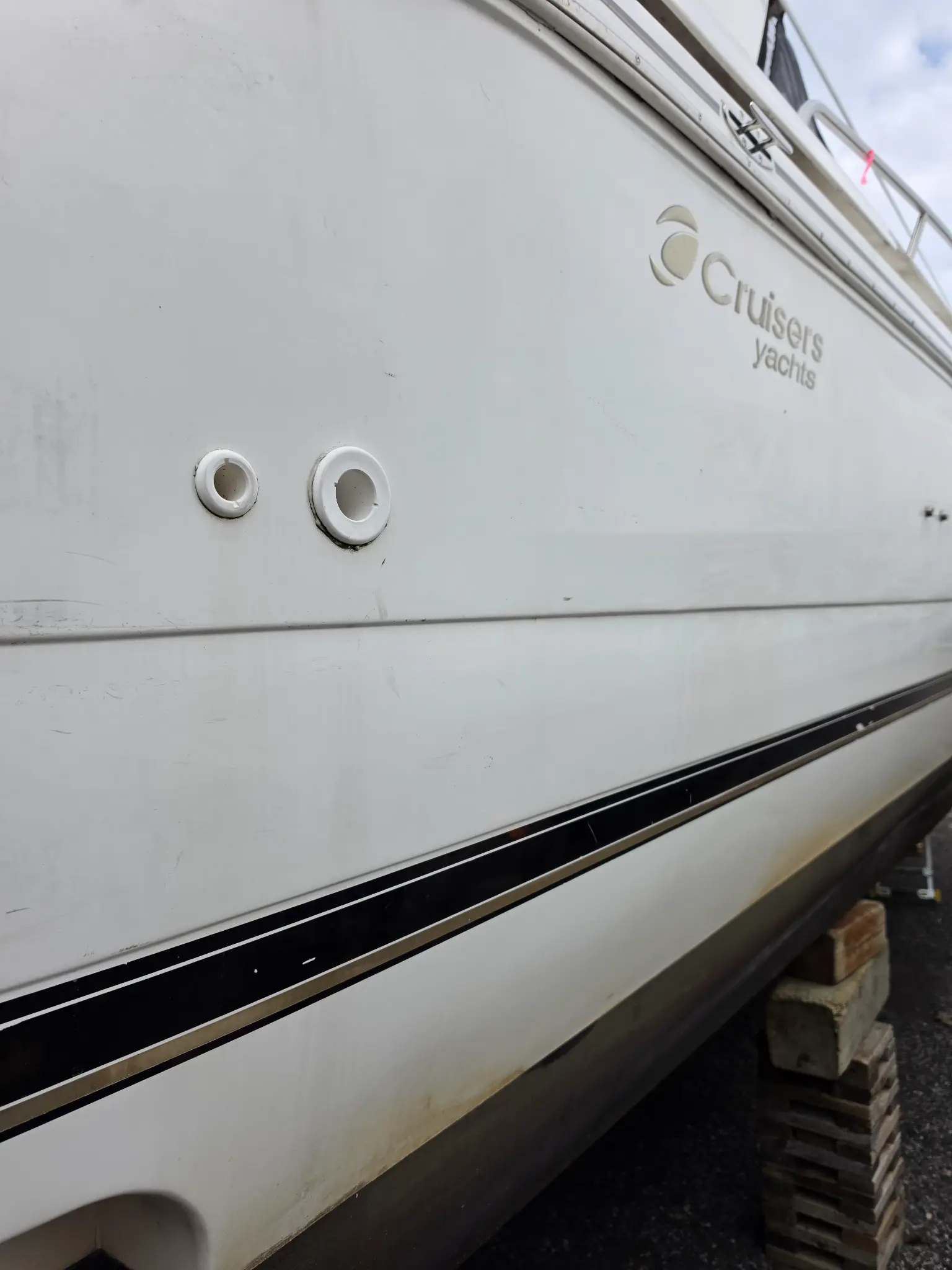 Cruisers Yachts hull before gelcoat restoration with oxidation, staining, and dull finish