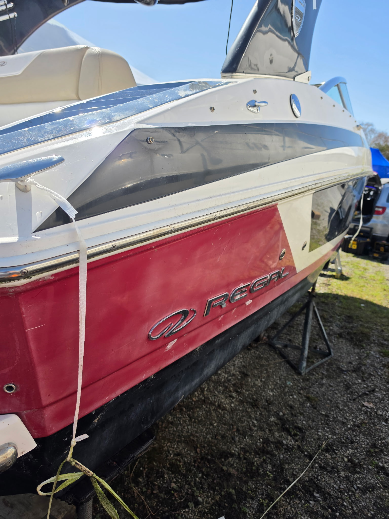 Regal boat stern before gelcoat restoration with reduced gloss and visible haze